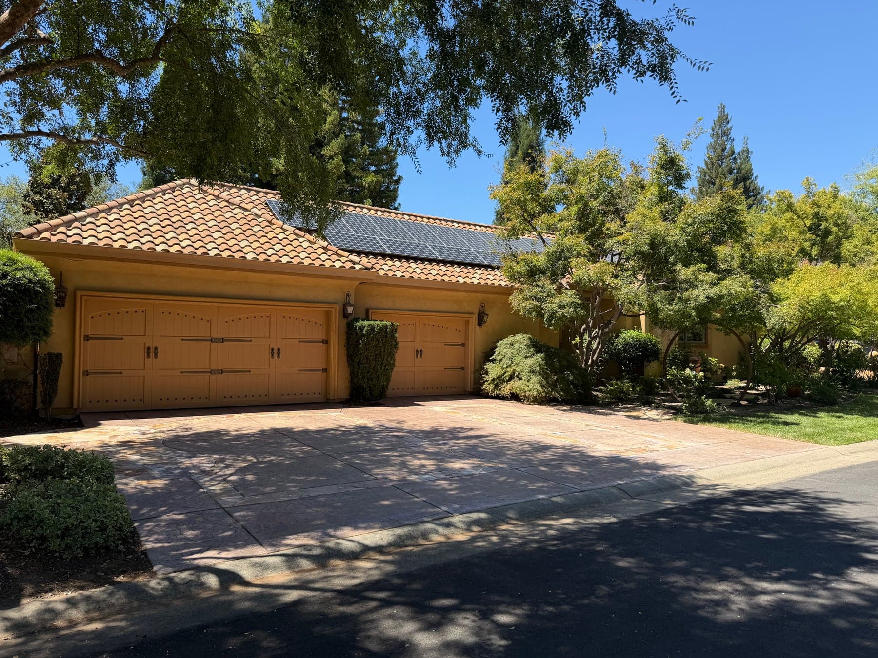 Solar array on a clay tile garage roof after cleaning — glass clear, cell grid visible