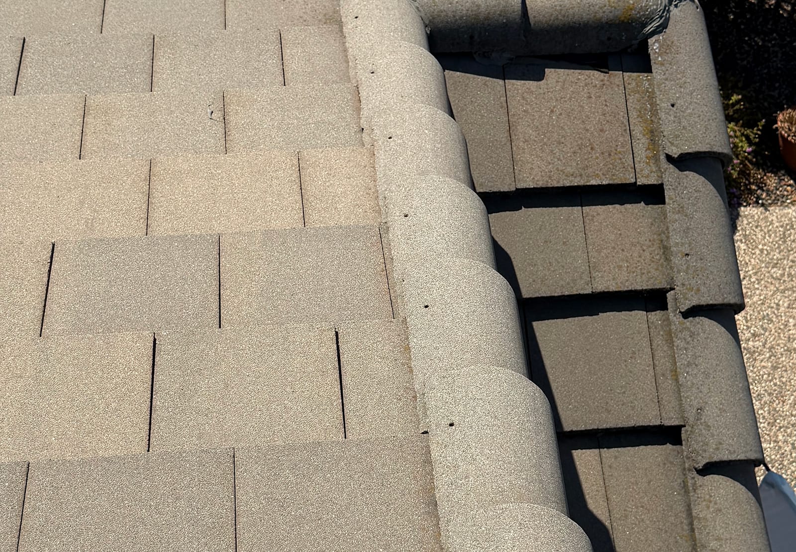 Flat concrete roof tiles at close range: soiling and growth have collected along the lap lines where each course overlaps the one below.